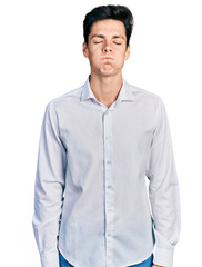 Young hispanic business man wearing business clothes puffing cheeks with funny face. mouth inflated with air, crazy expression.