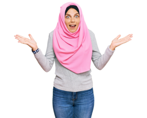 Young caucasian woman wearing traditional islamic hijab scarf celebrating victory with happy smile and winner expression with raised hands