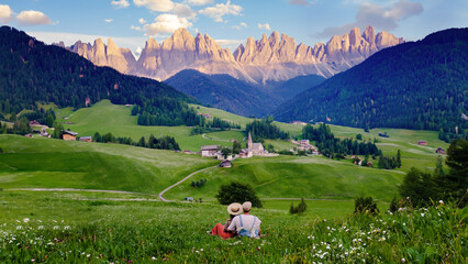 Santa Magdalena village Vall Di Funes Dolomites mountains, men and women on vacation in Italian...