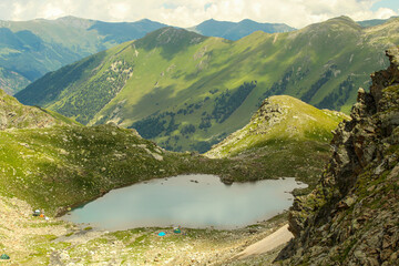Close up on the small Sophia lake with camps on bank. Arkhyz, Caucasus, Russia