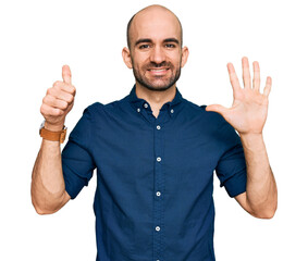Young hispanic man wearing casual clothes showing and pointing up with fingers number six while...