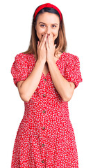Young beautiful girl wearing dress and diadem laughing and embarrassed giggle covering mouth with...
