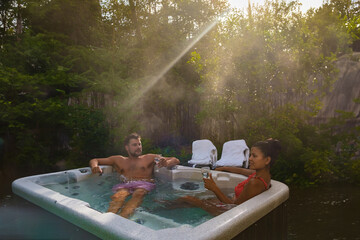 couple of men and woman in a hot tub bath in the rain forest of Vancouver Island, men and women in...