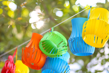 Colorful mobile paper handcraft decoration hanging on a tree in the garden.
