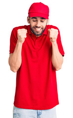 Young handsome man with beard wearing delivery uniform excited for success with arms raised and eyes closed celebrating victory smiling. winner concept.