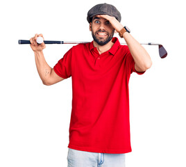 Young handsome man with beard playing golf holding club and ball stressed and frustrated with hand...