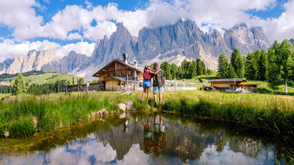 A couple of men and women at Geisleralm Rifugio Odle Dolomites Italy, men and woman hiking in the mountains of Val Di Funes in Italian Dolomites Adolf Munkel Trail in Puez Odle Nature Park