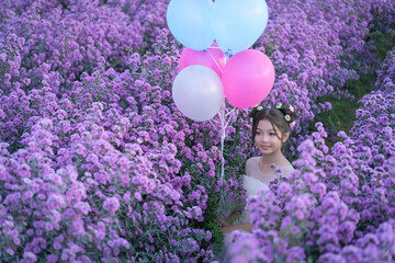 Happiness at Christmas and New Year celebrations with a Pretty young Asian Girl in a white dress among the beautiful blooming flowering field.