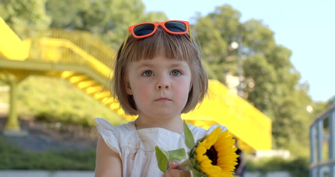 Pure and carefree joy of childhood. Child with a flower radiating happiness and feelings of innocence. Delightful moment girl is spinning or twirling with happiness while holding a flower in her hand