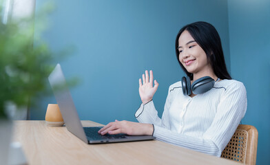 Portrait of nerd sme business asian woman work from home at headphone online computer desktop table...