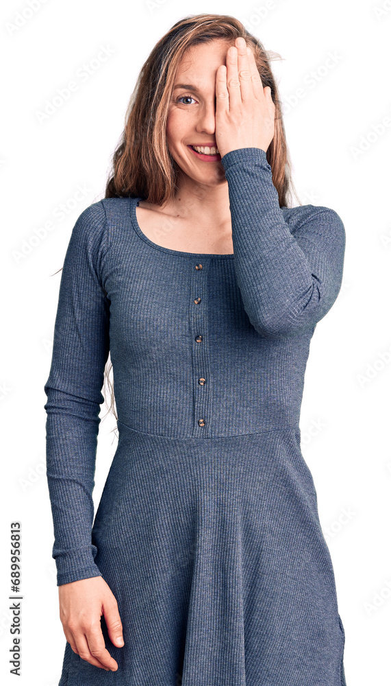 Canvas Prints Young beautiful blonde woman wearing casual dress covering one eye with hand, confident smile on face and surprise emotion.