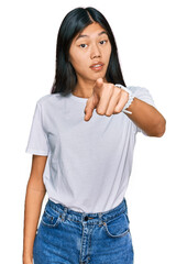 Beautiful young asian woman wearing casual white t shirt pointing displeased and frustrated to the camera, angry and furious with you
