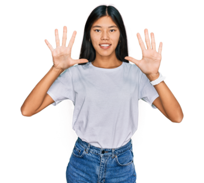 Beautiful young asian woman wearing casual white t shirt showing and pointing up with fingers number ten while smiling confident and happy.