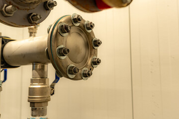 The interior of a mechanical room and a domestic potable water system with valves and connecting...