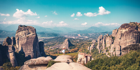 The Meteora- Rock formation and monastery in Greece, Woman with white dress enjoys panoramic view