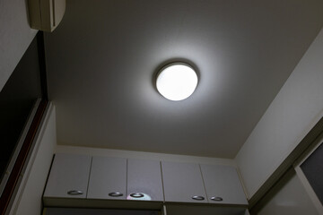 暗い部屋の天井で光る半球形の照明器具