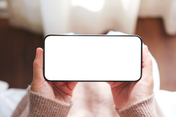 Top view mockup image of a woman holding mobile phone with blank desktop white screenTop view...