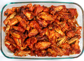 In a baking tray buffalo chicken wings are roasted.