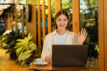 Young woman working on laptop at outdoor cafe garden during springtime, enjoying serenity ambient...