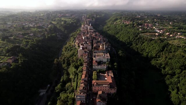 Aerial establishing 5th-century medieval town atop narrow ridge, Italy