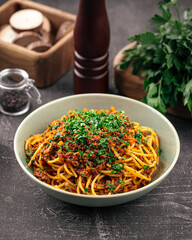 Portion of appetizing spaghetti bolognese with herbs