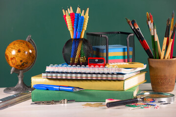 School supplies for primary and secondary school on the table, on a saint background. Back to...