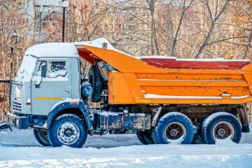 A snow-covered truck is parked on a winter day
