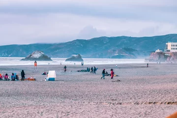 Photo sur Plexiglas Plage de Baker, San Francisco People watching the sunset on the ocean beach in San Francisco, beautiful landscape, concept for vacation, travel, relaxation