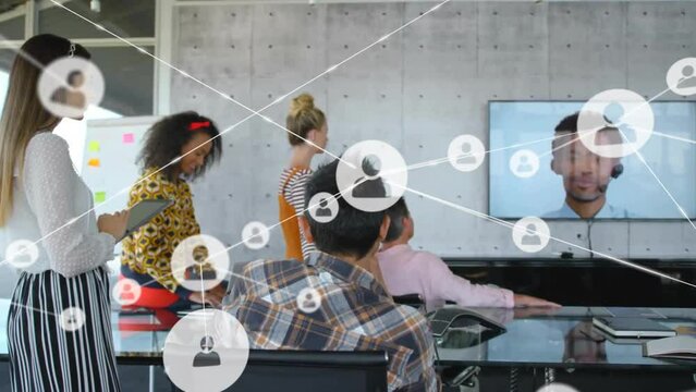 Animation of network of connections with icons over diverse colleagues having meeting in office