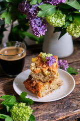 Blondie with white chocolate and walnuts. Side view, wooden background, rustic, lilac flowers.
