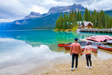 Emerald Lake Yoho National Park Canada British Colombia. a beautiful lake in the Canadian Rockies during the autumn season. A couple of men and women standing by the lake with arms together