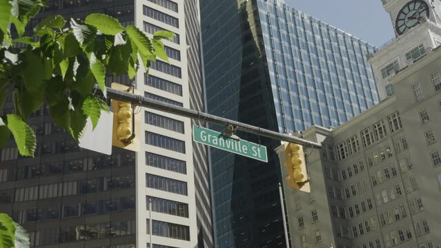 Granville Street crossing in Vancouver, street sign with buildings in the background, handheld parallax.