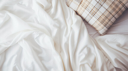 White bedding with warm plaid. Cozy background