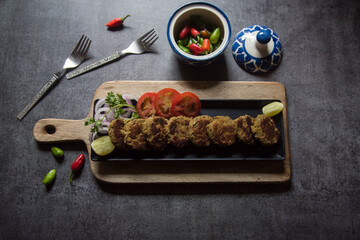 Meat kebab pieces served in a black tray with use of selective focus