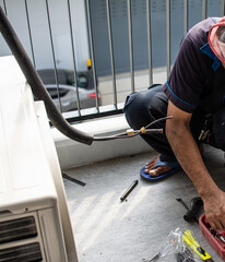 Technician  install  air conditioner outdoor unit