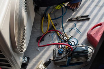 Air conditioning, HVAC service technician using gauges to check refrigerant and add refrigerant...