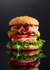 Burger on a black reflective background.