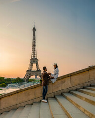 Young couple by Eiffel Tower at Sunrise Paris Eifel Towe, man woman in love valentine concept in Paris the city of love. Men and women visiting the Eiffel Tower honeymoon trip