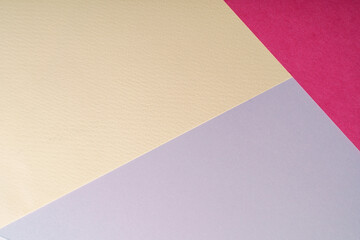 Multi colored abstract paper of pastel gray,pink,yellow,magenta colors palette, with geometric shape, flat lay.