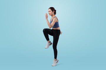 Side view young athletic asian woman on running posture in studio shot on isolated background....