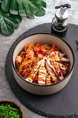 Asian rice noodles with vegetables, sauce and chicken in a bowl