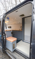 Open door of a van reveals custom camper conversion