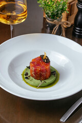 salmon tartare with black caviar on a blue plate