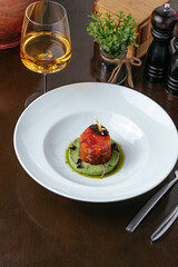 salmon tartare with black caviar on a blue plate