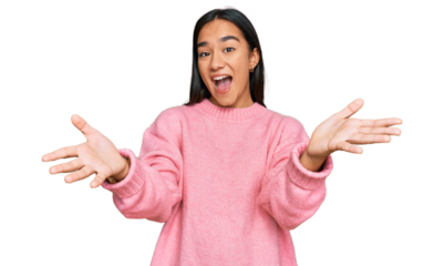 Young asian woman wearing casual winter sweater smiling cheerful offering hands giving assistance and acceptance.