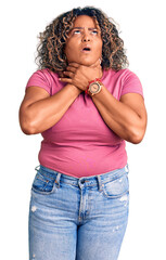 Young african american plus size woman wearing casual clothes shouting suffocate because painful...