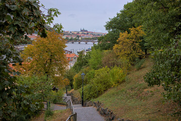 Fototapeta premium Panoramic view of Prague from Vysehrad with bridges over the Vltava river, Prague Castle in the background. Romantic panorama of the city, historical buildings, red roofs, river.