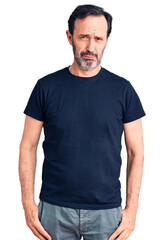 Obraz premium Middle age handsome man wearing casual t-shirt depressed and worry for distress, crying angry and afraid. sad expression.