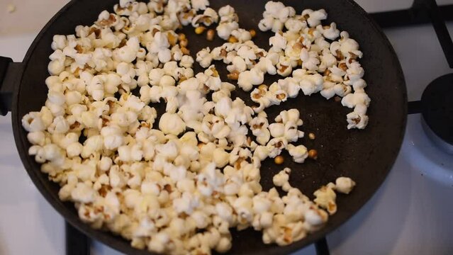 Popcorn was made from small corn kernels in a frying pan on a gas stove burner.