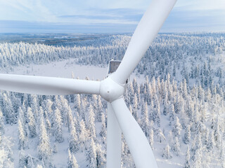 Wind turbine. Aerial view of wind turbine closeup and snow covered woods in Finland.